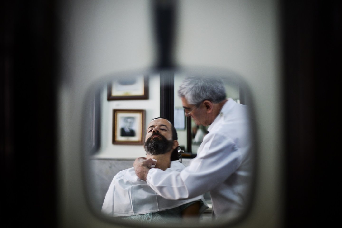 A barber shaves the beard of a customer at the barber shop "Barbearia Campos", open since 1886, in Lisbon on July 16, 2013. AFP PHOTO/ PATRICIA DE MELO MOREIRA (Photo credit should read PATRICIA DE MELO MOREIRA/AFP/Getty Images)