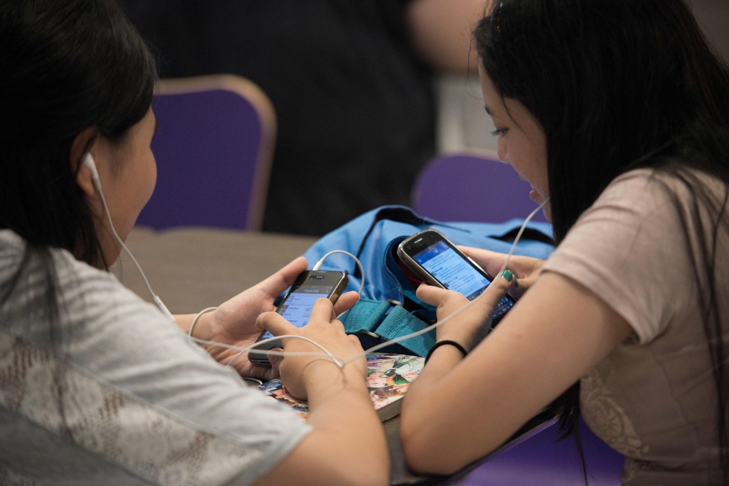 This picture taken on March 21, 2013 shows two young woman typing on their smartphones at a shopping mall in Bangkok. A recent Facebook-sponsored study showed smartphone owners are often connected all day. People can be found glued to their smartphones at airports, on trains, in restaurants and even while walking on the street, creating a disconnection from their immediate surroundings. Smartphone sales are expected to continue to surge in 2013 with some 918 million units to be bought worldwide. AFP PHOTO / Nicolas ASFOURI (Photo credit should read NICOLAS ASFOURI/AFP/Getty Images)