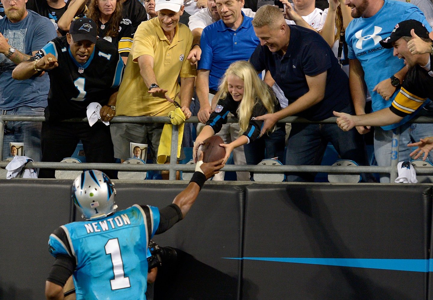 CHARLOTTE, NC - SEPTEMBER 21: Cam Newton #1 of the Carolina Panthers gives a fan a ball after a 3rd quarter touchdown against the Pittsburgh Steelers during their game at Bank of America Stadium on September 21, 2014 in Charlotte, North Carolina. (Photo by Grant Halverson/Getty Images)