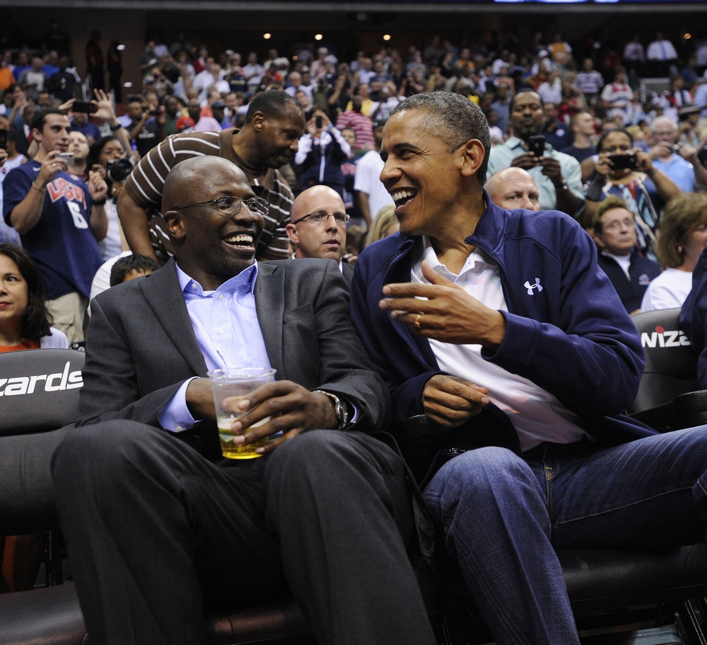 WASHINGTON, DC - JULY 16: U.S. President Barack Obama shares a laugh with former White House aide Reggie Love as they watch the US Senior Men's National Team and Brazil play during a pre-Olympic exhibition basketball game at the Verizon Center on July 16, 2012 in Washington, DC. (Photo by Leslie E. Kossoff-Pool/Getty Images)