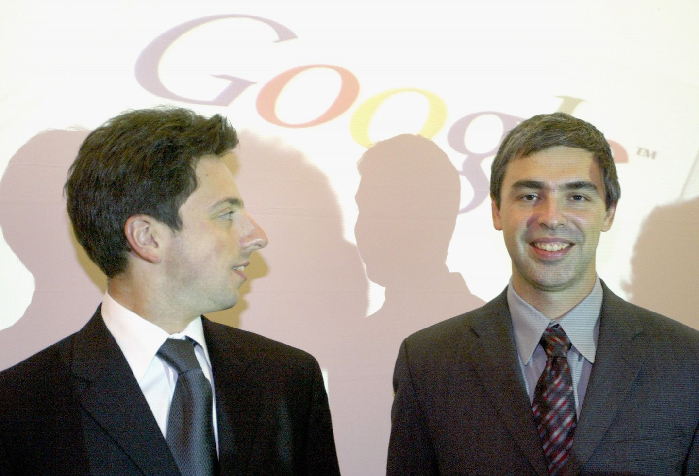 FRANKFURT, GERMANY - OCTOBER 7: Google founders Sergey Brin (L) and Larry Page (R) joke prior to a news conference during the opening of the Frankfurt bookfair on October 7, 2004 in Frankfurt, Germany. The Frankfurt Bookfair is the world's largest event of it's type and this year's focal theme "Literature of Arabia" will run until October 10, 2004. (Photo by Ralph Orlowski/Getty Images)