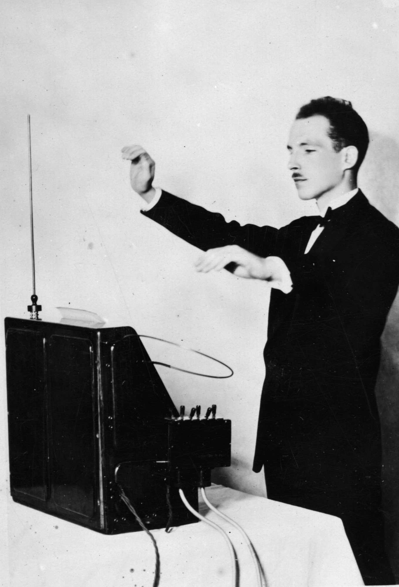 12th December 1927: Professor Leon Theremin demonstrating his theremin. The theremin was the world's first electronic musical instrument. It is played without actually touching any part of the instrument. Film scores of the 40s and 50s used the instrument to eerie effect and it makes a famous appearance in the chorus of the Beach Boys hit 'Good Vibrations'. (Photo by Topical Press Agency/Getty Images)