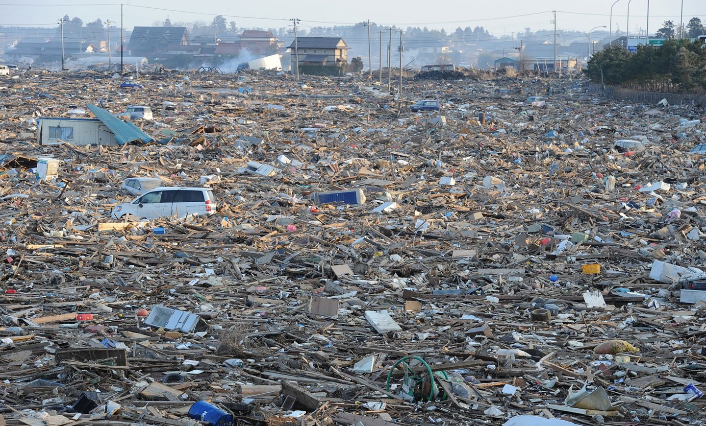 Debris cover a large area in Natori, near Sendai in Miyagi prefecture on March 13, 2011 after the March 11 earthquake and tsunami. Japan battled a feared meltdown of two reactors at a quake-hit nuclear plant, as the full horror of the disaster emerged on the ravaged northeast coast where more than 10,000 were feared dead. An explosion at the ageing Fukushima No. 1 atomic plant blew apart the building housing one of its reactors on March 12, a day after the biggest quake ever recorded in Japan unleashed a monster 10-metre (33-foot) tsunami. AFP PHOTO/MIKE CLARKE (Photo credit should read MIKE CLARKE/AFP/Getty Images)