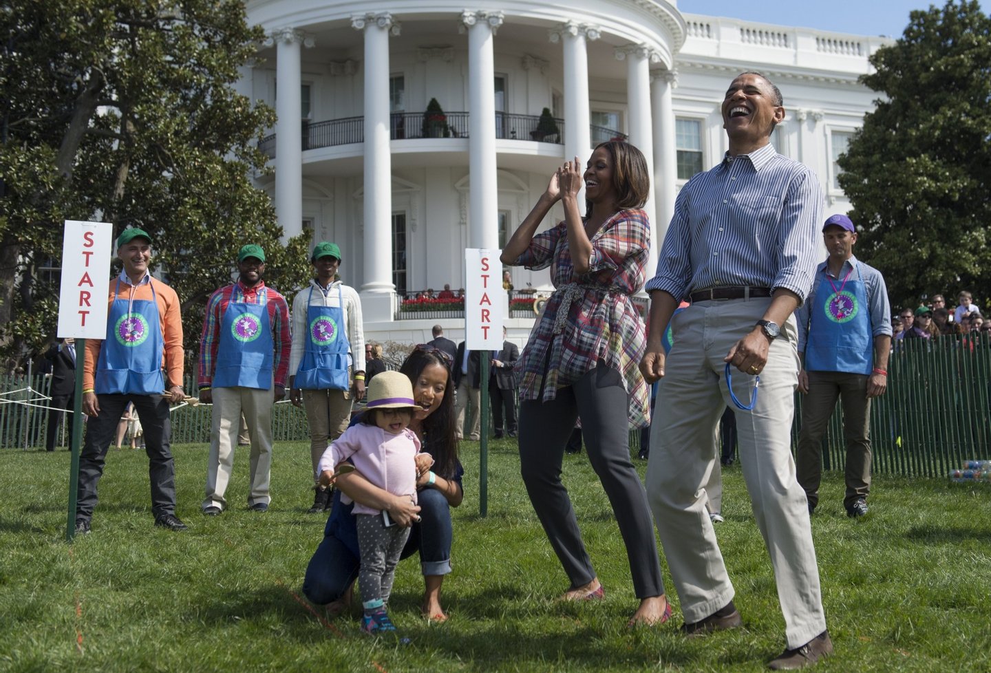 US President Barack Obama and First Lady Michelle Obama react to a child rolling an Easter egg during the annual White House Easter Egg Roll on the South Lawn of the White House in Washington, DC, April 21, 2014. The 126th annual White House Easter Egg Roll, the largest annual public event at the White House with more than 30,000 attendees expected, features live music, sports courts, cooking stations, storytelling and Easter egg rolling, with the theme, "Hop into Healthy, Swing into Shape." AFP PHOTO / Saul LOEB (Photo credit should read SAUL LOEB/AFP/Getty Images)