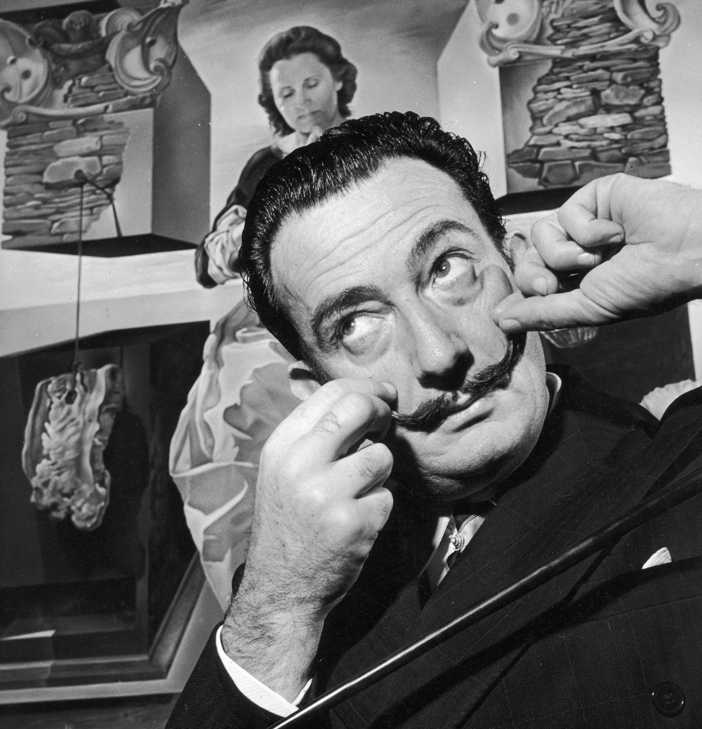 Spanish surrealist artist Salvador Dali (1904 - 1989) in London with one of his paintings entitled 'The Madonna of Port Lligat', December 1951. (Photo by George Konig/Keystone Features/Getty Images)
