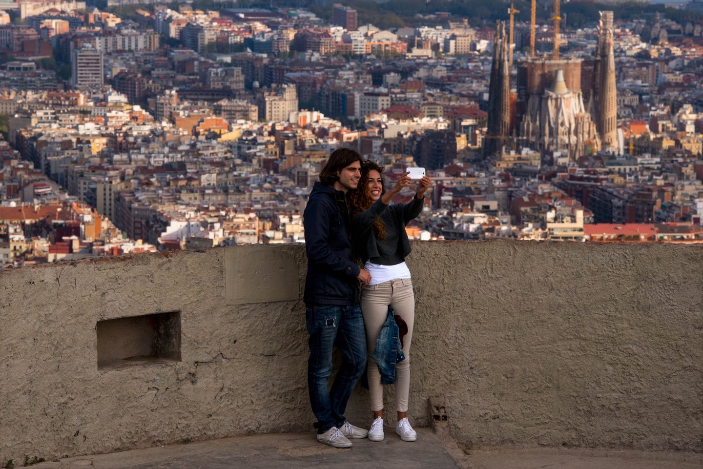 BARCELONA, SPAIN - APRIL 10: A couple take a selfie as they enjoy the views over the city on April 10, 2015 in Barcelona, Spain. Barcelona's city hall has put a regulation in motion that bans large tourist groups visiting Barcelona's most popular market. Barcelona's authorities are debating how to control the number of tourist in the city as an estimated 10 million people are due to visit this year. (Photo by David Ramos/Getty Images)