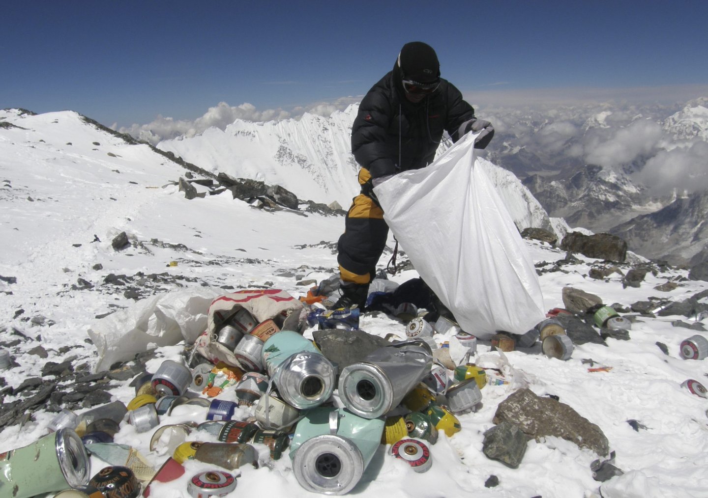 This picture taken on May 23, 2010 shows a Nepalese sherpa collecting garbage, left by climbers, at an altitude of 8,000 metres during the Everest clean-up expedition at Mount Everest. A group of 20 Nepalese climbers, including some top summiteers collected 1,800 kilograms of garbage in a high-risk expedition to clean up the world's highest peak. Led by seven-time summiteer Namgyal Sherpa, the team braved thin air and below freezing temperatures to clear around two tonnes of rubbish left behind by mountaineers, that included empty oxygen cylinders and corpses. Since 1953, there have been some 300 deaths on Everest. Many bodies have been brought down, but those above 8,000 metres have generally been left to the elements -- their bodies preserved by the freezing temperatures. The priority of the sherpas had been to clear rubbish just below the summit area, but coordinator Karki said large quantities of refuse was collected from 8,000 meters and below. AFP PHOTO/Namgyal SHERPA (Photo credit should read NAMGYAL SHERPA/AFP/Getty Images)