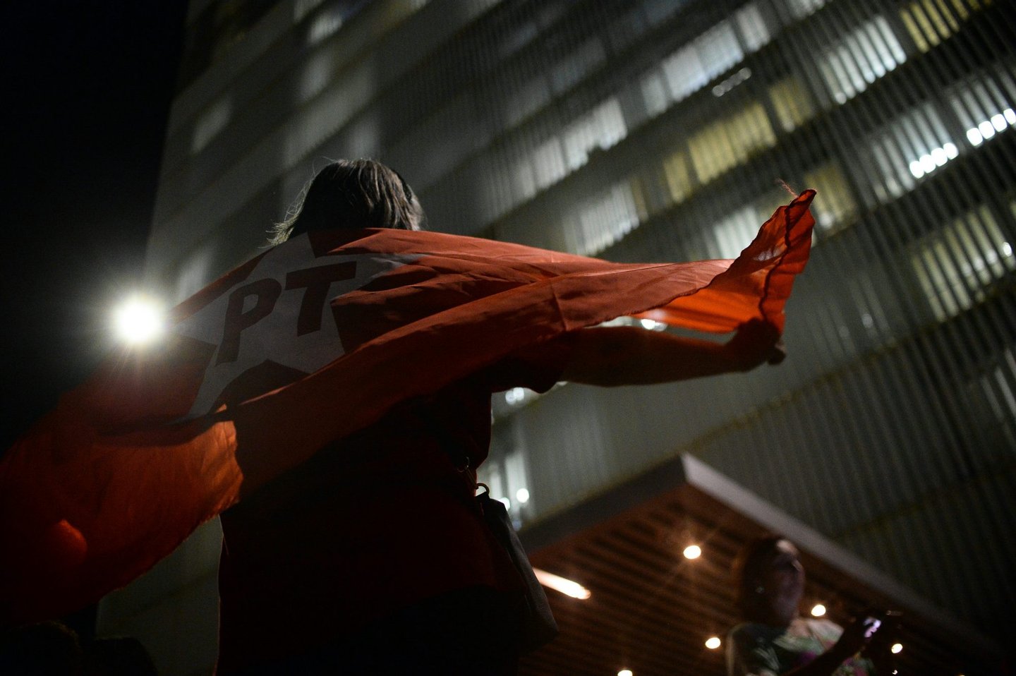 A supporters of the government of Brazilian President Dilma Rousseff demonstrates wrapped in a Workers