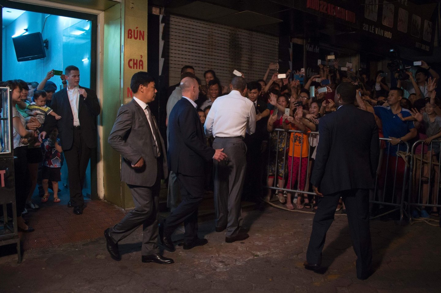 US President Barack Obama (C) shakes hands with locals after eating dinner at Bun cha Huong Lien with CNN's Anthony Bourdain in Hanoi late on May 23, 2016. Obama praised "strengthening ties" between the United States and Vietnam at the start of a landmark visit on May 23, as the former wartime foes deepen trade links and share concerns over Chinese actions in disputed seas. / AFP / JIM WATSON (Photo credit should read JIM WATSON/AFP/Getty Images)