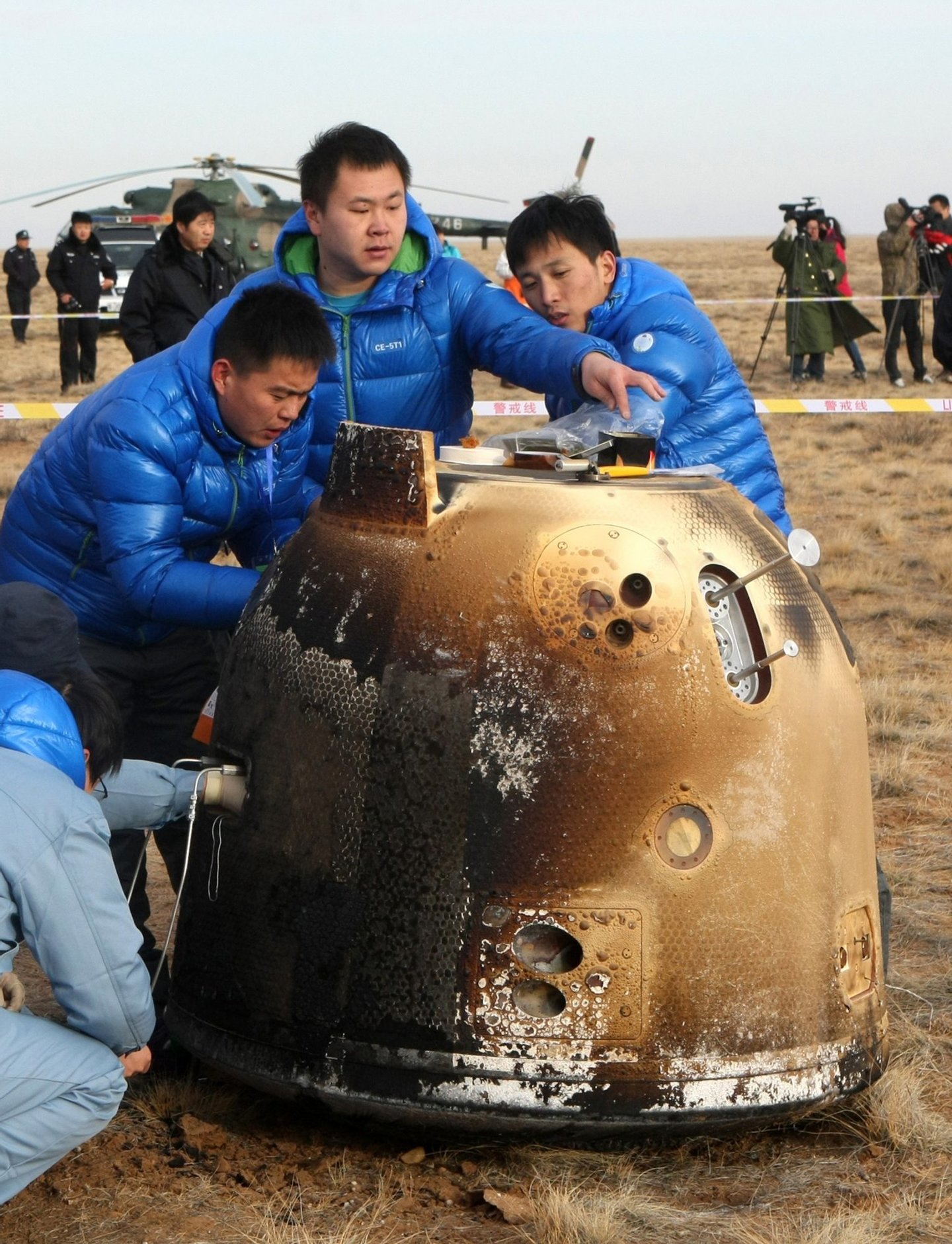 This picture taken on November 1, 2014 shows technicians checking the unmanned probe landed in Dorbod (Siziwang) Banner, north China's Inner Mongolia region. China completed its first return mission to the moon early on November 1 with the successful re-entry and landing of an unmanned probe, state media reported, in the latest step forward for Beijing's ambitious space programme. CHINA OUT AFP PHOTO (Photo credit should read STR/AFP/Getty Images)