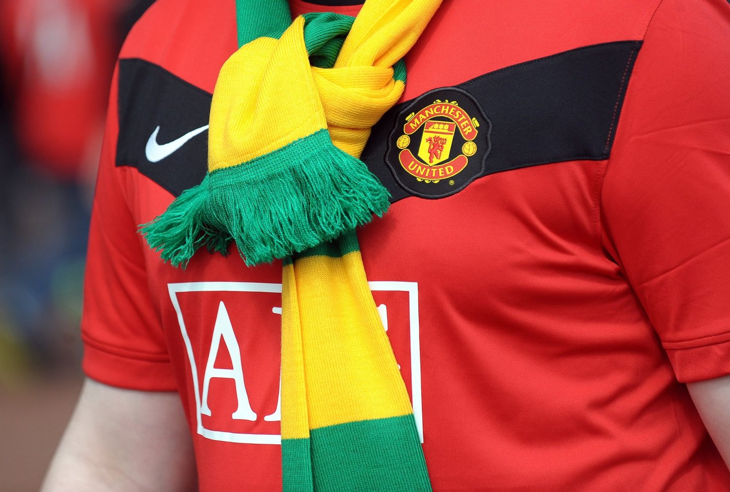 A Manchester United supporter wears a green and gold scarf in protest against the Glazer family's owenership of the club ahead of their English Premier League football match against Tottenham Hotspur at Old Trafford in Manchester, north-west England, on April 24, 2010. AFP PHOTO/PAUL ELLIS - FOR EDITORIAL USE ONLY Additional licence required for any commercial/promotional use or use on TV or internet (except identical online version of newspaper) of Premier League/Football League photos. Tel DataCo +44 207 2981656. Do not alter/modify photo. (Photo credit should read PAUL ELLIS/AFP/Getty Images)