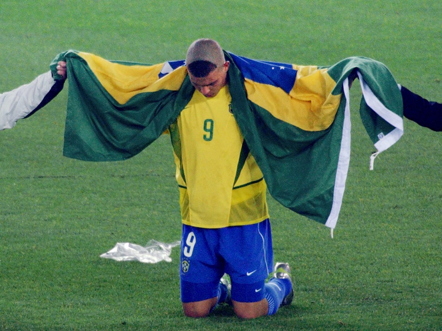 Brazil's forward Ronaldo, wrapped in the national colors, celebrates in silence on the pitch of the International Stadium Yokohama, Japan after Brazil won 2-0 against Germany in match 64 of the 2002 FIFA World Cup Korea Japan final 30 June, 2002. Ronaldo scored the two winning goals, giving Brazil its fifth World Cup title. AFP PHOTO ROBERTO SCHMIDT (Photo credit should read ROBERTO SCHMIDT/AFP/Getty Images)