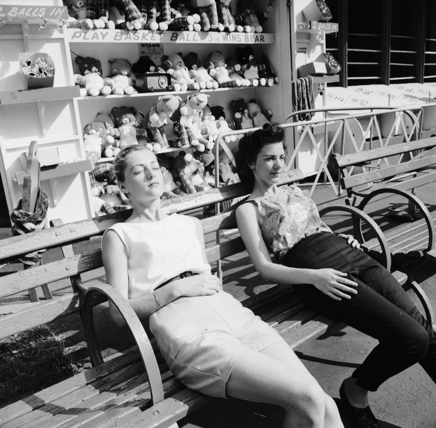 circa 1956: Two girls take a break from their summer jobs at the Palisades Amusement Park, New Jersey to bask in the noontime sun. (Photo by Sherman/Three Lions/Getty Images)