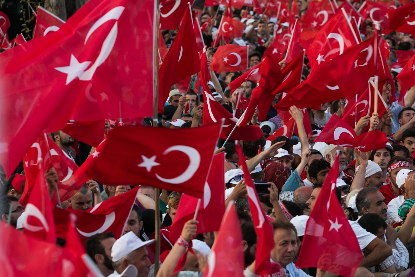 Supporters wave Turkish national flags as Turkish President (unseen) arrives during a rally near his house in Istanbul on July 16, 2016 after Turkish authorities wrested back control of the Ataturk airport.  President Recep Tayyip Erdogan urged Turks to remain on the streets on July 16, 2016, as his forces regained control after a spectacular coup bid by discontented soldiers that claimed more than 250 lives. Describing the attempted coup as a "black stain" on Turkey's democracy, Yildirim said that 161 people had been killed in the night of violence and 1,440 wounded. / AFP / GURCAN OZTURK        (Photo credit should read GURCAN OZTURK/AFP/Getty Images)
