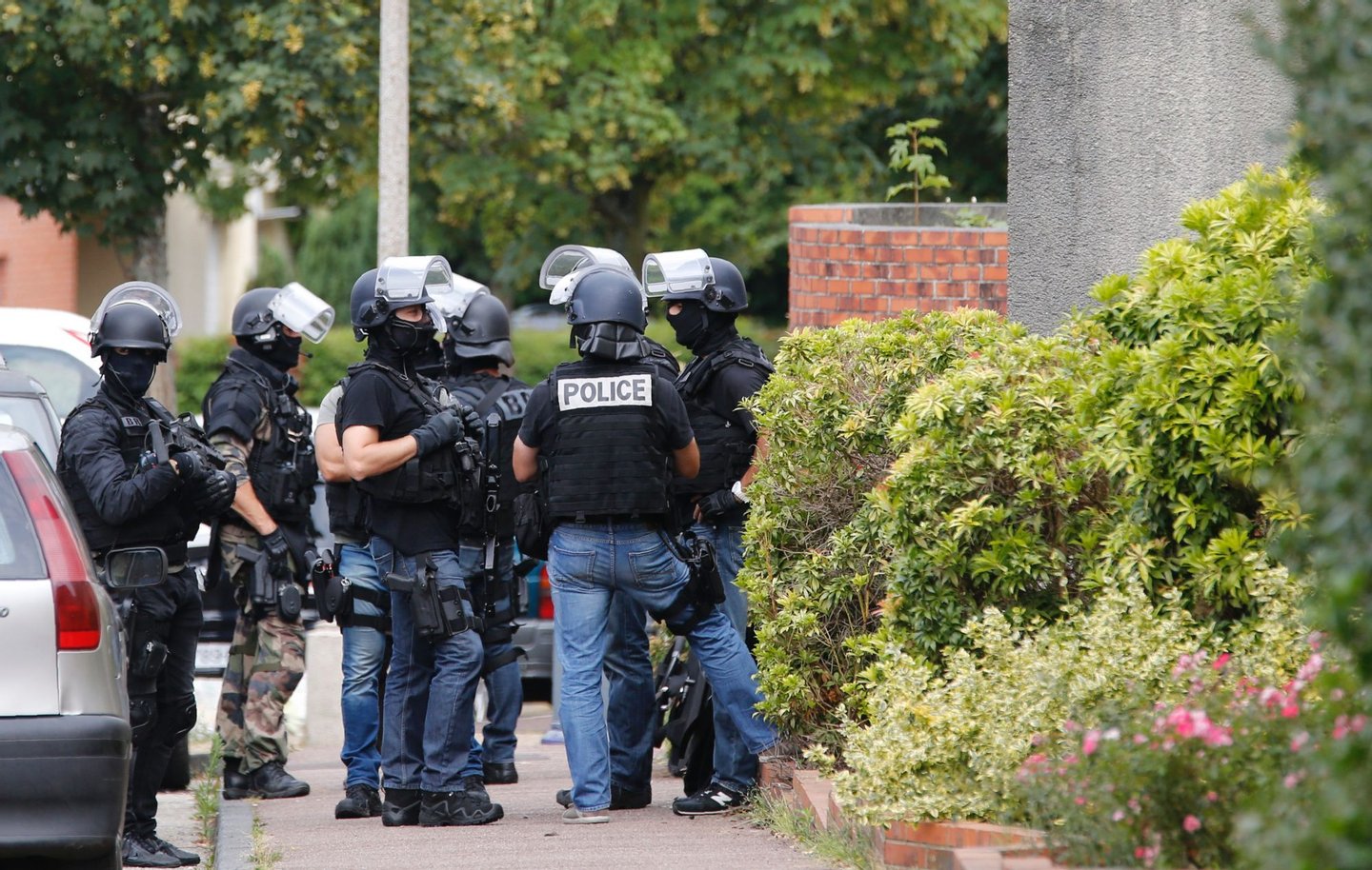 French policemen stand in a street during a search in a house on July 26, 2016 in the Normandy village of Saint-Etienne du Rouvray after a priest was killed in the latest of a string of attacks against Western targets claimed by or blamed on the Islamic State jihadist group. French President said that two men who attacked a church and slit the throat of a priest had "claimed to be from Daesh", using the Arabic name for the Islamic State group. Police said they killed two hostage-takers in the attack in the Normandy town of Saint-Etienne-du-Rouvray, 125 kilometres (77 miles) north of Paris. / AFP / MATTHIEU ALEXANDRE (Photo credit should read MATTHIEU ALEXANDRE/AFP/Getty Images)