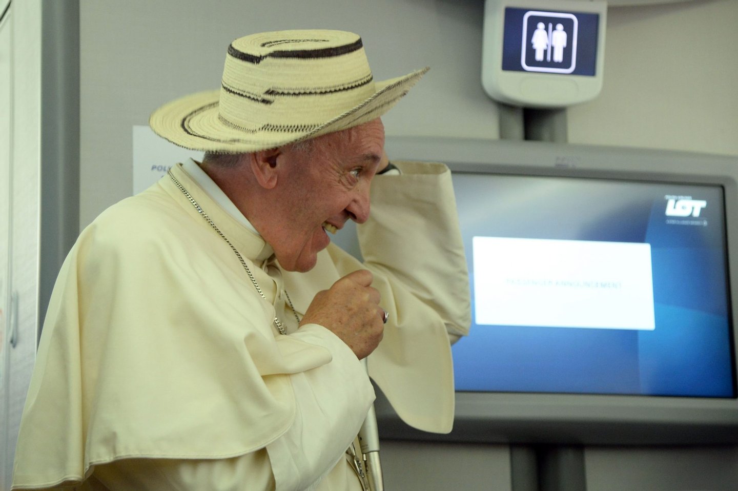 Pope Francis reacts while wearing a hat during a press conference on the plane after his visit to Krakow for the World Youth Days, on July 31, 2016. Pope Francis celebrated mass on July 31, 2016 with over 1.5 million pilgrims in a vast sun-drenched field in Poland, wrapping up an emotionally charged trip with some choice technological metaphors. In a nod to today's internet-dominated world, Francis urged the faithful, who had travelled to Poland from all over the world, to "download the best link of all, that of a heart which sees and transmits goodness without growing weary". / AFP / POOL AND AFP / Filippo MONTEFORTE (Photo credit should read FILIPPO MONTEFORTE/AFP/Getty Images)