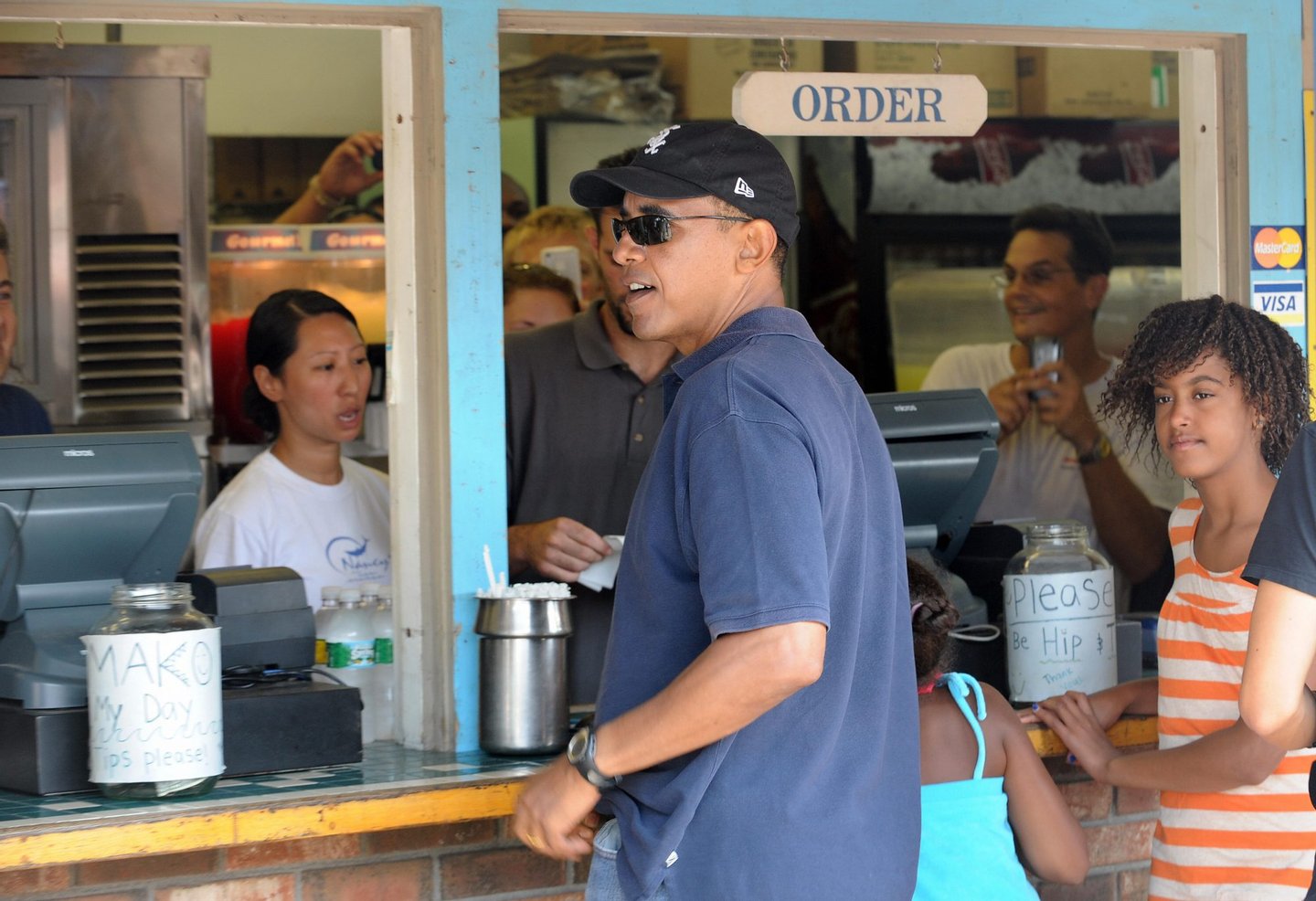 US President Barack Obama and his daughters Malia and Sasha (hidden)order their lunch at Nancy's fast food restaurant in Oak Bluffs on Martha's Vineyard, Massachusetts, on August 26, 2009. AFP PHOTO/Jewel SAMAD (Photo credit should read JEWEL SAMAD/AFP/Getty Images)