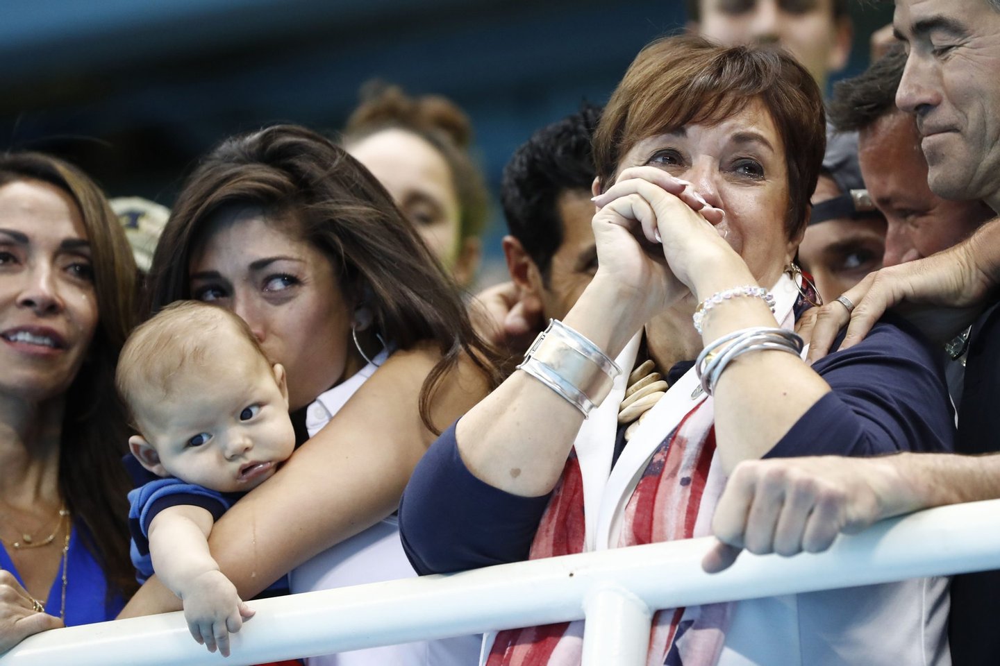 USA's Michael Phelps' mother Deborah (R) and partner Nicole Johnson holding Michael Phelps' son, Boomer cry during the podium ceremony of the Men's swimming 4 x 100m Medley Relay Final at the Rio 2016 Olympic Games at the Olympic Aquatics Stadium in Rio de Janeiro on August 13, 2016. / AFP / Odd ANDERSEN (Photo credit should read ODD ANDERSEN/AFP/Getty Images)
