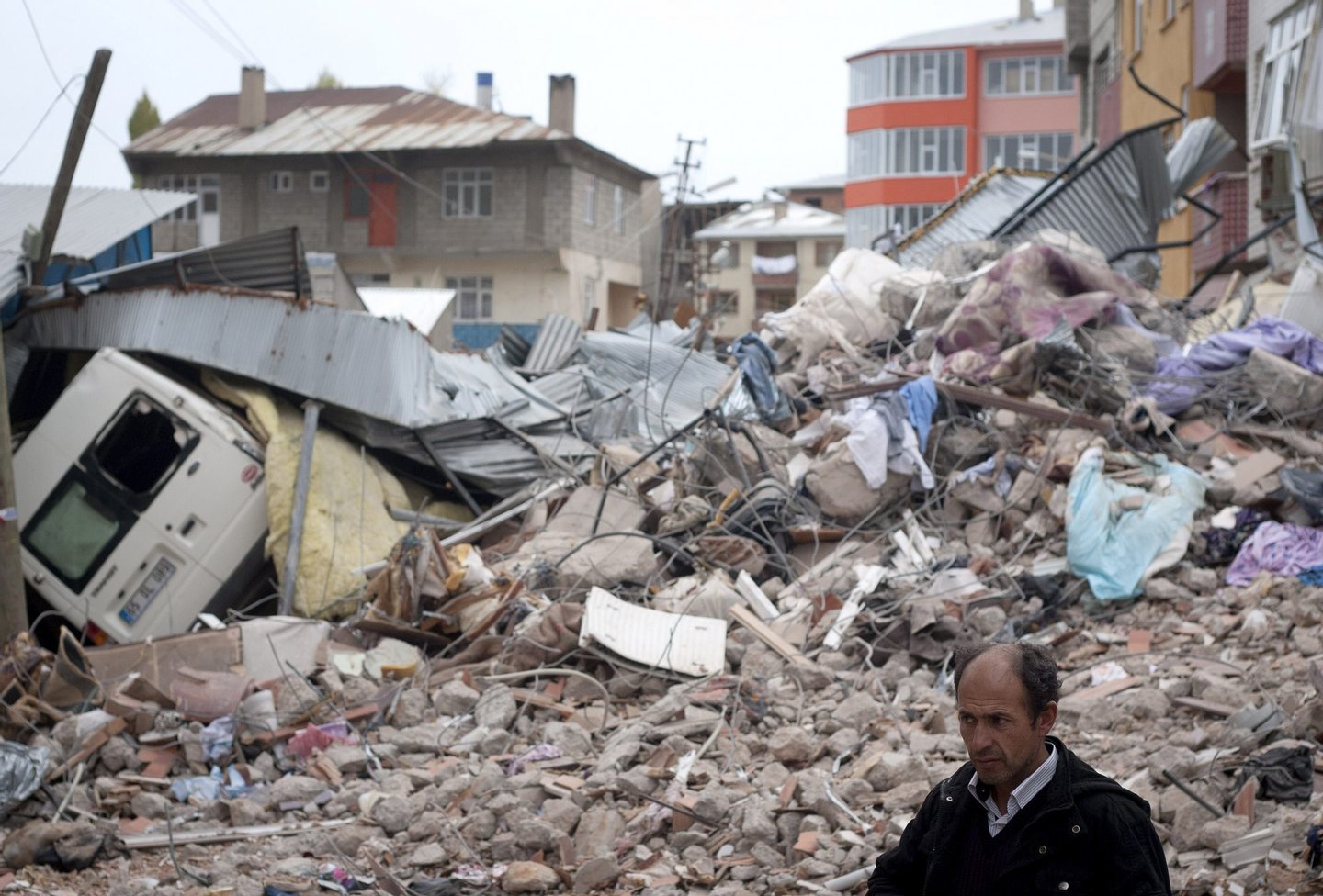 VAN, TURKEY - OCTOBER 26: A Turkish man stands in front of a ruined building after an earthquake, on October 26, 2011 in Van, Turkey. Media are reporting more than 400 people have been killed in the 7.2 earthquake that struck in Eastern Turkey on October 23. The earthquake has left up to 40,000 people homeless in almost freezing conditions. (Photo by Ahmad Halabisaz/Getty Images)