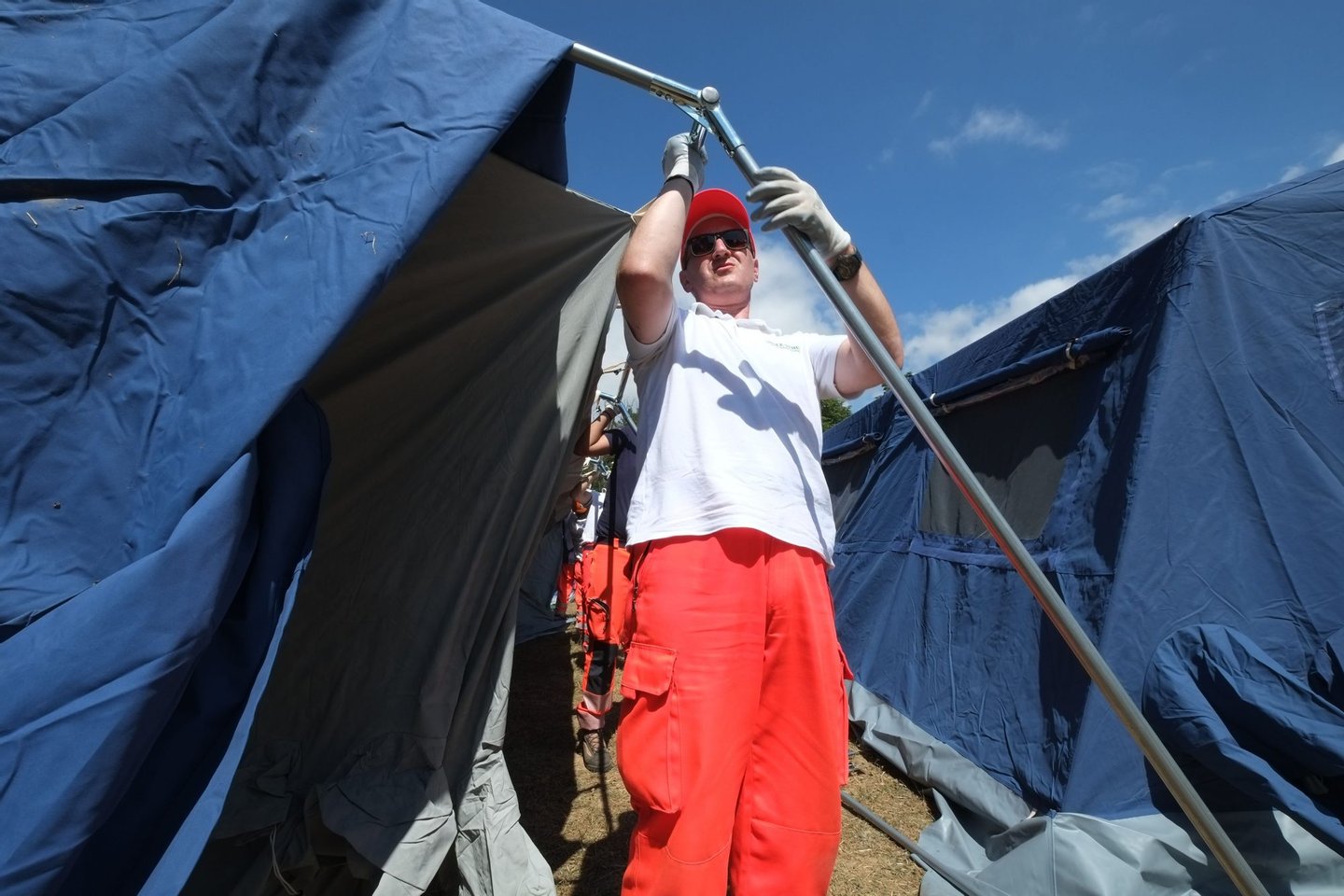 A volunteer erects a tent at a temporary encampment for residents of earthquake in the central Italian village of Amatrice, on August 25, 2016, a day after a 6.2-magnitude earthquake struck the region killing some 247 people. The death toll from a powerful earthquake in central Italy was revised downwards to 241 but officials cautioned it could rise again as rescuers continued a grim search for corpses, as powerful aftershocks rocked the devastated area. / AFP / MARIO LAPORTA (Photo credit should read MARIO LAPORTA/AFP/Getty Images)