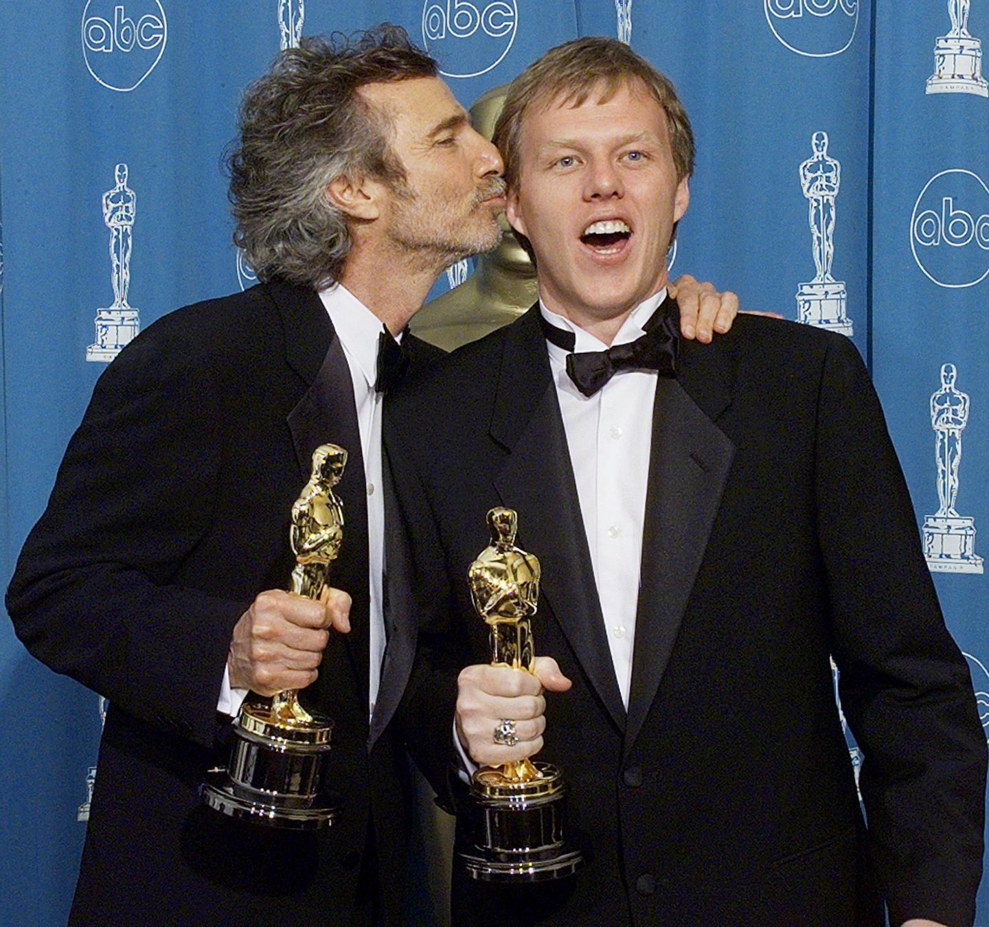 LOS ANGELES, UNITED STATES: Oscar winners for Best Adapted Screenplay Curtis Hanson (L) and Brian Helgelow, pose for photographers 23 March at the 70th Annual Academy Awards at the Shrine Auditorium in Los Angeles. (ELECTRONIC IMAGE) AFP PHOTO/Hector MATA (Photo credit should read HECTOR MATA/AFP/Getty Images)