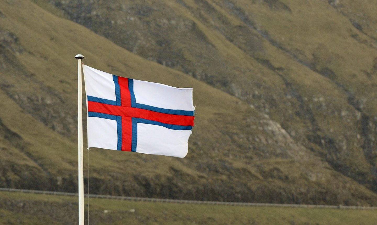 The Faroe Islands flag is pictured at the Vestmanna village Streymoy island on October 14, 2012, Faroe Islands. The Faroe Islands are known for its fishing and sheep farming as the main industries. AFP PHOTO / JONATHAN NACKSTRAND (Photo credit should read JONATHAN NACKSTRAND/AFP/Getty Images)