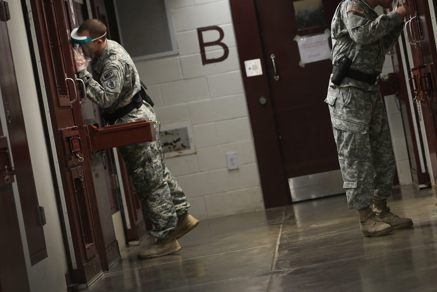 GUANTANAMO BAY, CUBA - JUNE 26: (EDITORS NOTE: Image has been reviewed by the U.S. Military prior to transmission.) U.S. Army Military Police check on detainees in a cell block during morning prayer at Camp V in the U.S. military prison for 'enemy combatants' on June 26, 2013 in Guantanamo Bay, Cuba. President Barack Obama has recently spoken again about closing the prison which has been used to hold prisoners from the invasion of Afghanistan and the war on terror since early 2002. (Photo by Joe Raedle/Getty Images)