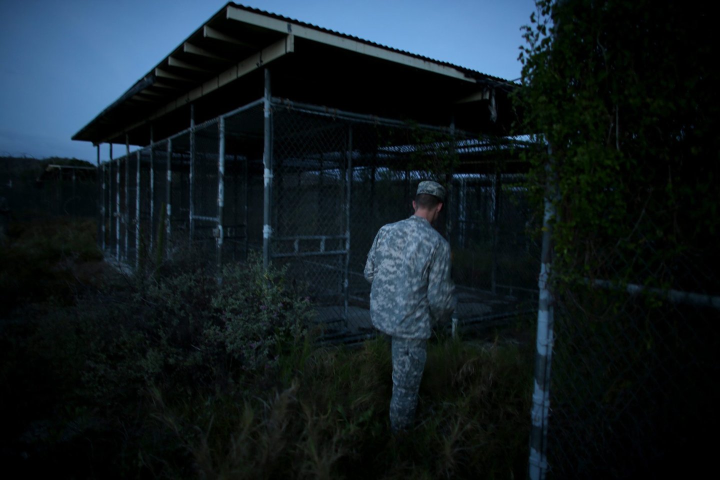 GUANTANAMO BAY, CUBA - JUNE 27: (EDITORS NOTE: Image has been reviewed by the U.S. Military prior to transmission.) A Public Affairs Officer escorts media through the currently closed Camp X-Ray which was the first detention facility to hold 'enemy combatants' at the U.S. Naval Station on June 27, 2013 in Guantanamo Bay, Cuba.The U.S. Naval Station at Guantanamo Bay, houses the American detention center for 'enemy combatants'. President Barack Obama has recently spoken again about closing the prison which has been used to hold prisoners from the invasion of Afghanistan and the war on terror since early 2002. (Photo by Joe Raedle/Getty Images)