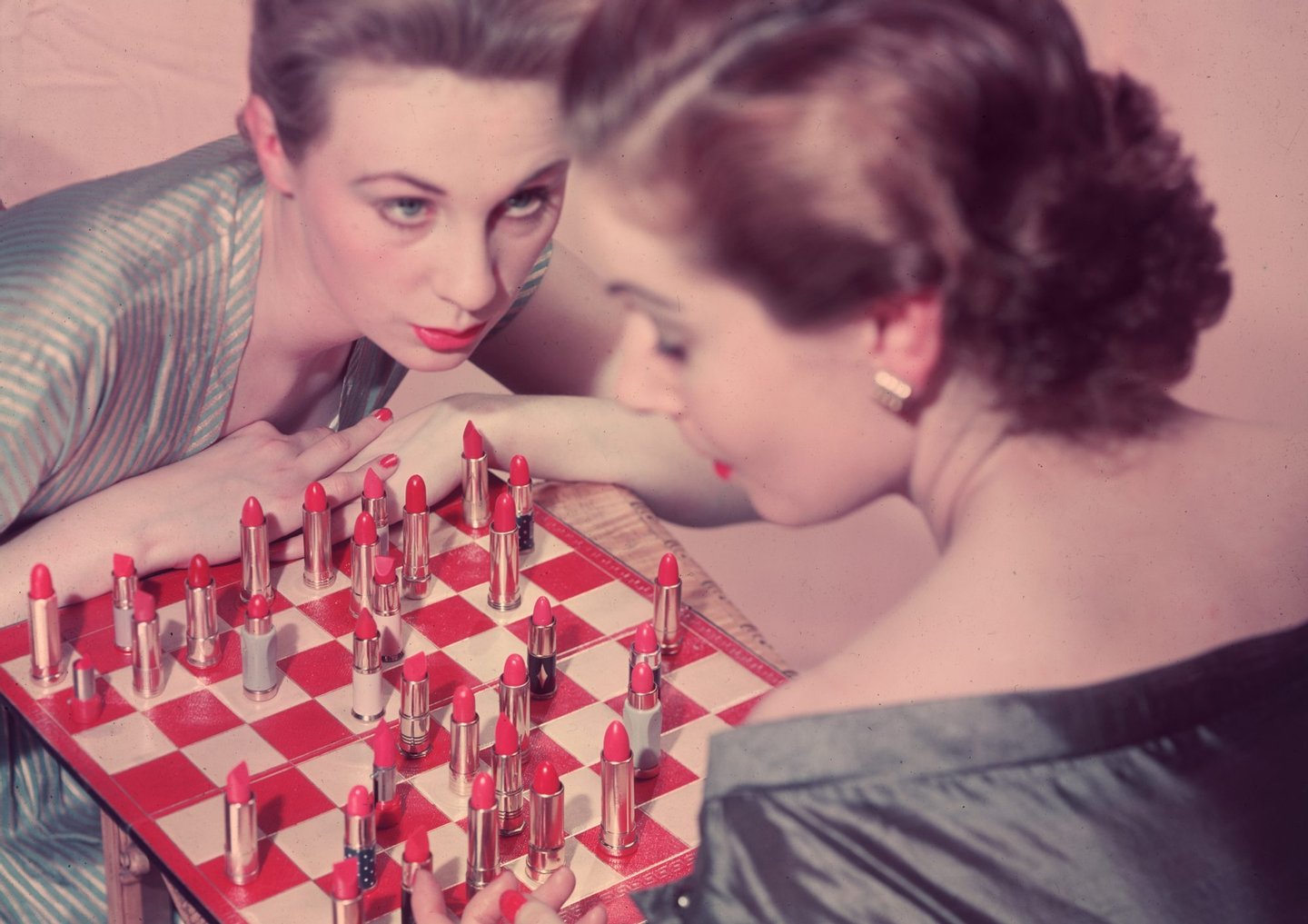 circa 1955: Two women playing an unusual game of chess, with lipstick instead of chess pieces. (Photo by Chaloner Woods/Getty Images)