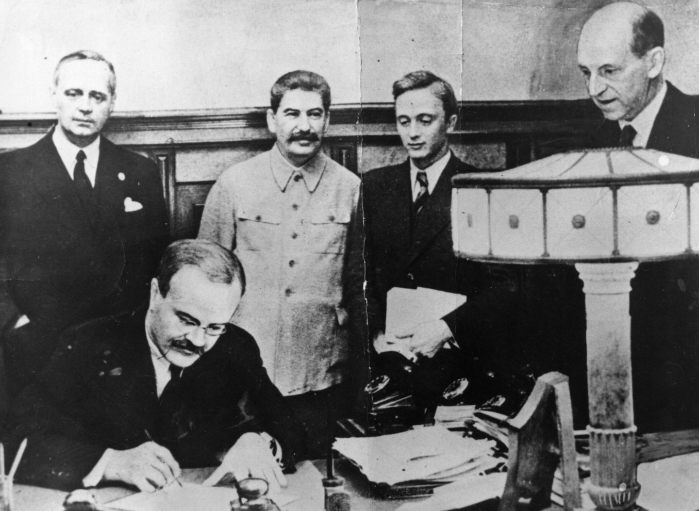 23rd August 1939: Vyacheslav Molotov, Russian Foreign Minister, signs the non-aggression pact negotiated between Soviet Russia and Germany, at the Kremlin, Moscow. Standing behind him is his German counterpart Joachim von Ribbentrop (left), and Joseph Stalin (centre). (Photo by Keystone/Getty Images)