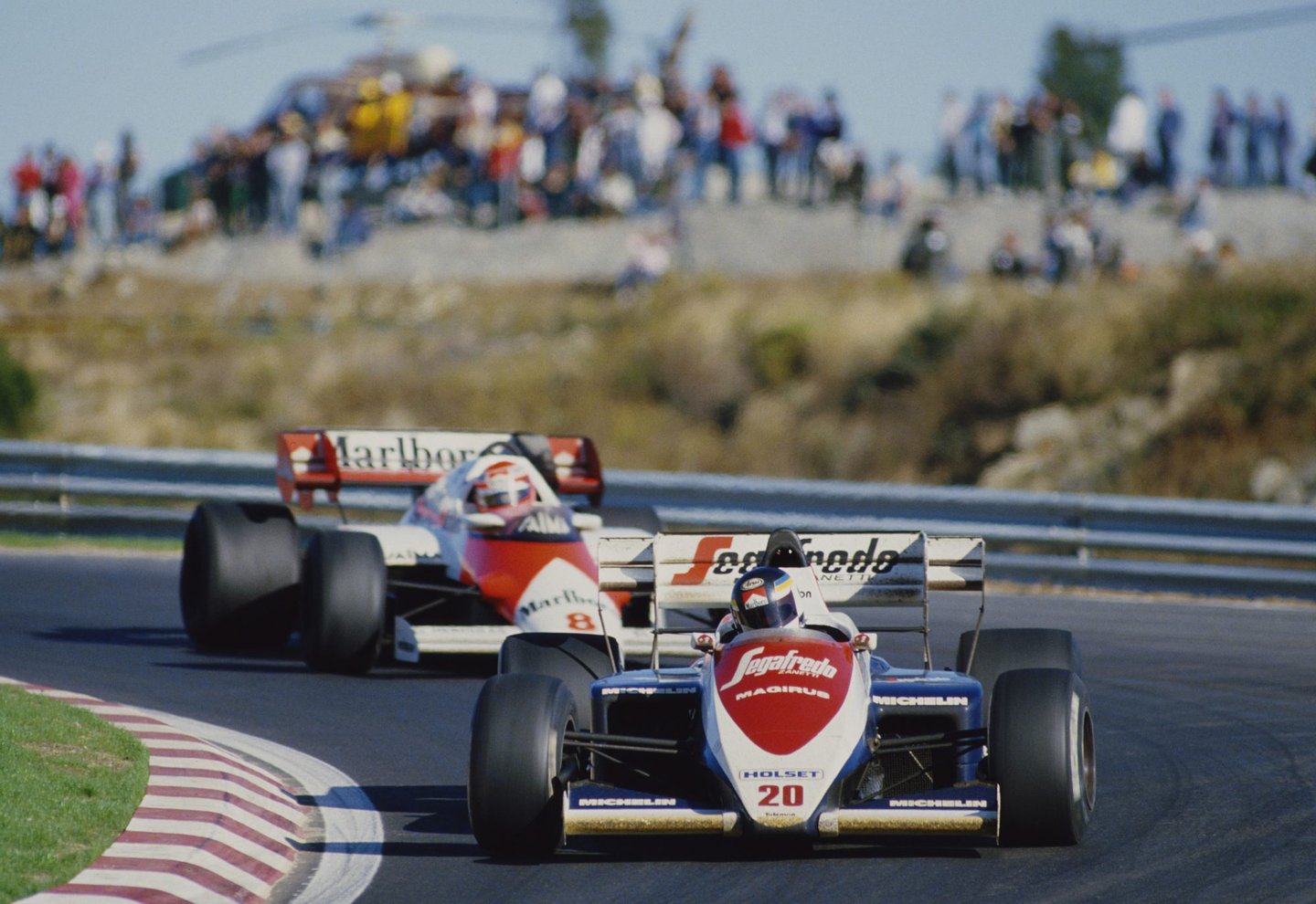 Stefan Johansson of Sweden drives the #20 Toleman Group Motorsport Toleman TG184 Hart Straight-4 turbo ahead of Niki Lauda during the Portuguese Grand Prix on 21st October 1984 at the Autodromo do Estoril in Estoril, Portugal. (Photo by Mike Powell/Getty Images)