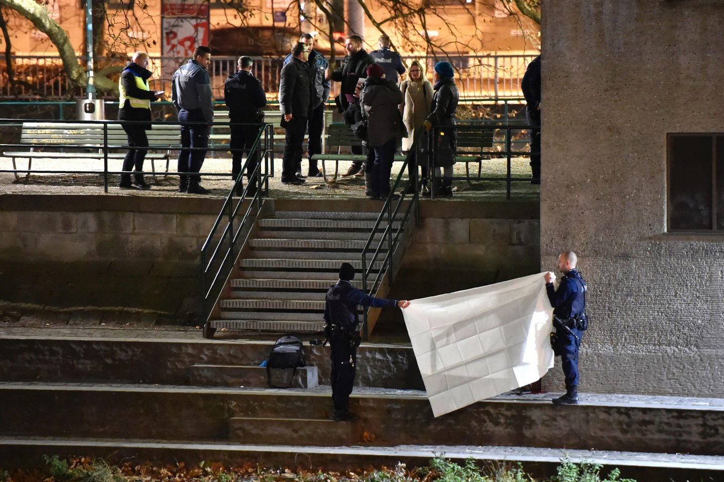 Swiss police officers hold a blanket to cover a dead body found near a Muslim prayer hall, central Zurich, on December 19, 2016, after three people were injured by gunfire. Local media reported the incident occurred in the Muslim prayer hall near the city's railway station. Swiss media said the three wounded people, all adults, were found in the street where the prayer hall is located. The suspected assailant had fled the scene and police sealed off the area. / AFP / MICHAEL BUHOLZER (Photo credit should read MICHAEL BUHOLZER/AFP/Getty Images)