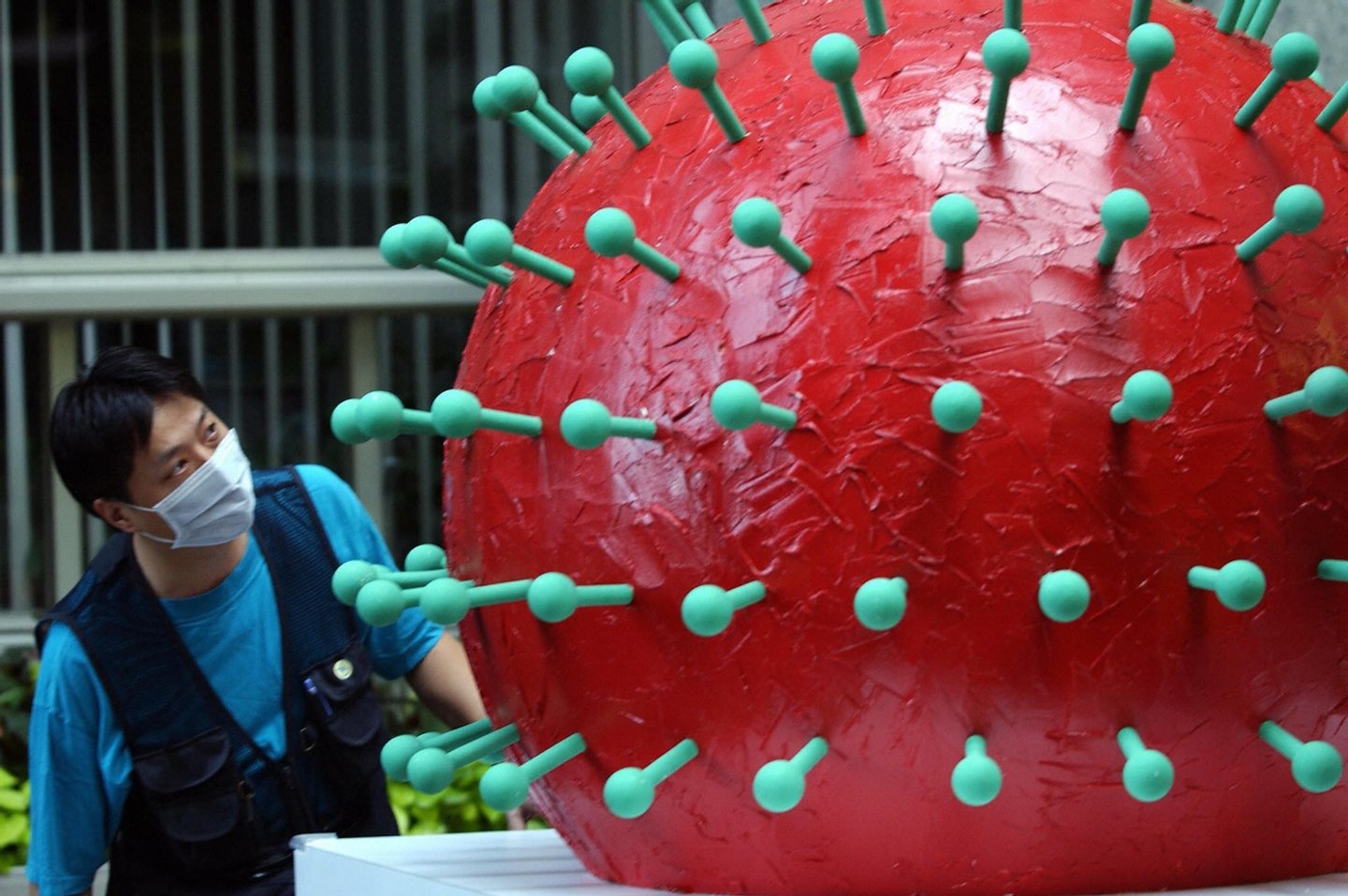 A masked man looks at a model of the coronavirus of SARS at city hall in Taipei, 17 May 2003.  Taiwan replaced its health minister Twu Shiing-jer on May16 as anger mounted over the government's handling of the SARS crisis, while hopes grew that Singapore would become the third country to declare victory over the disease.   AFP PHOTO/Sam YEH  (Photo credit should read SAM YEH/AFP/Getty Images)